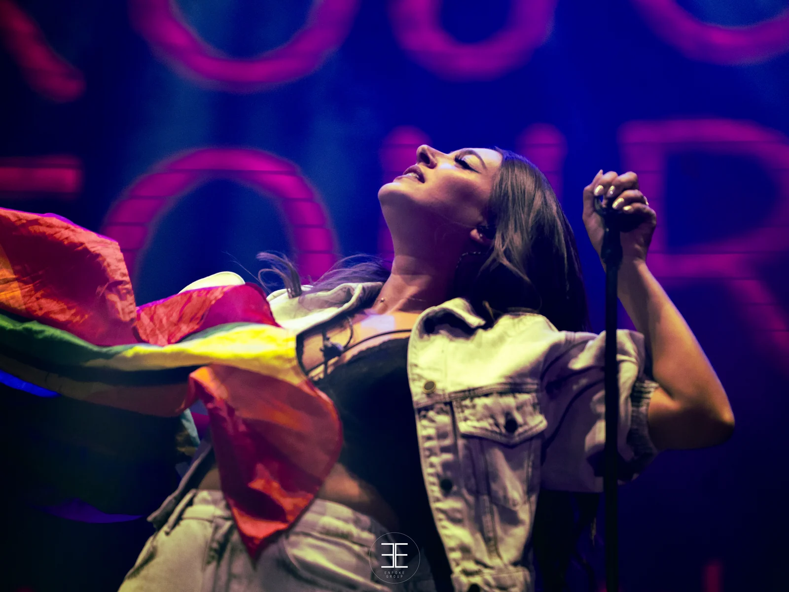 Ana Guerra echa la cabeza hacia atrás cantando mientras la bandera arcoíris vuela a su lado