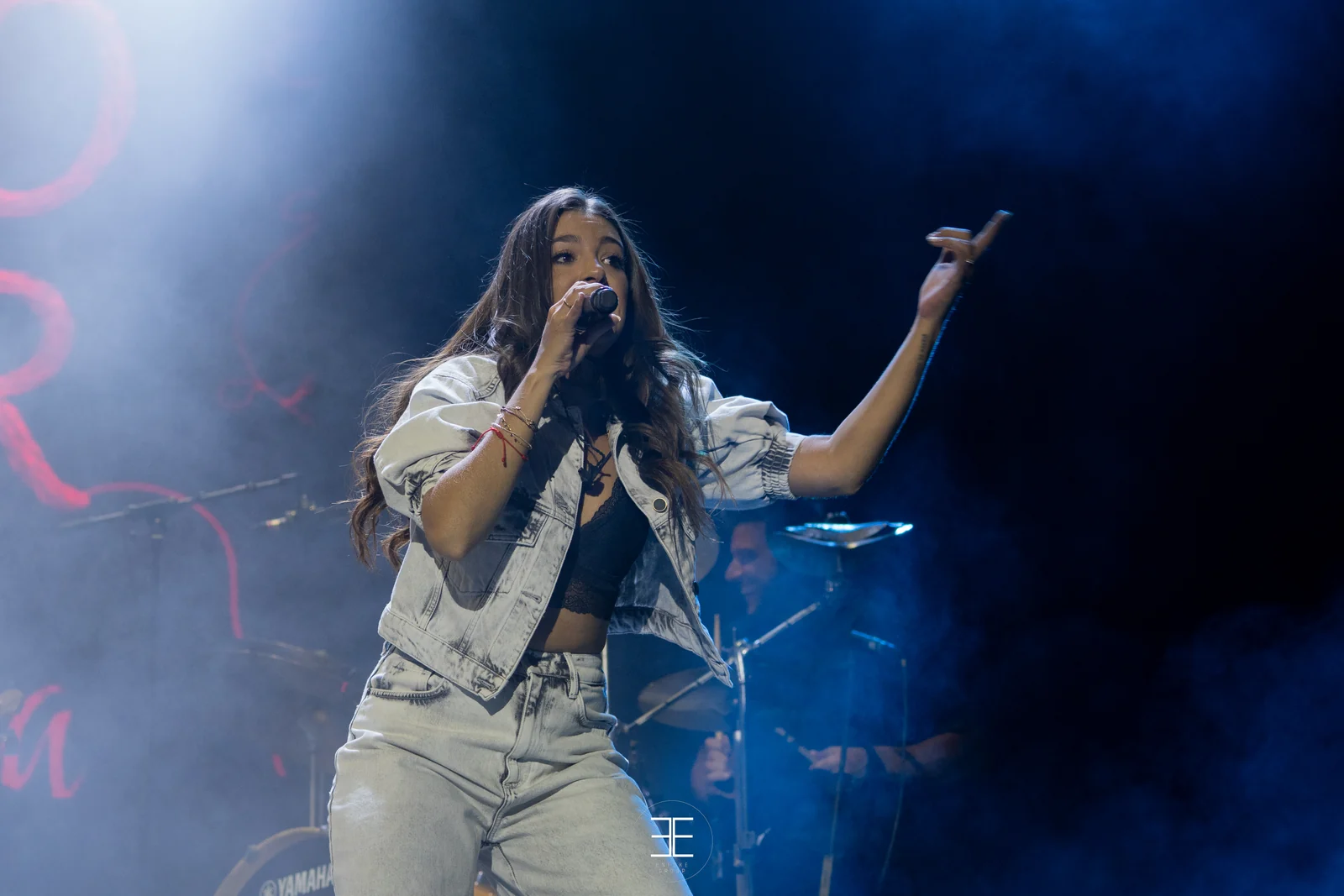 Ana Guerra canta con un brazo extendido entre el humo, con la batería al fondo
