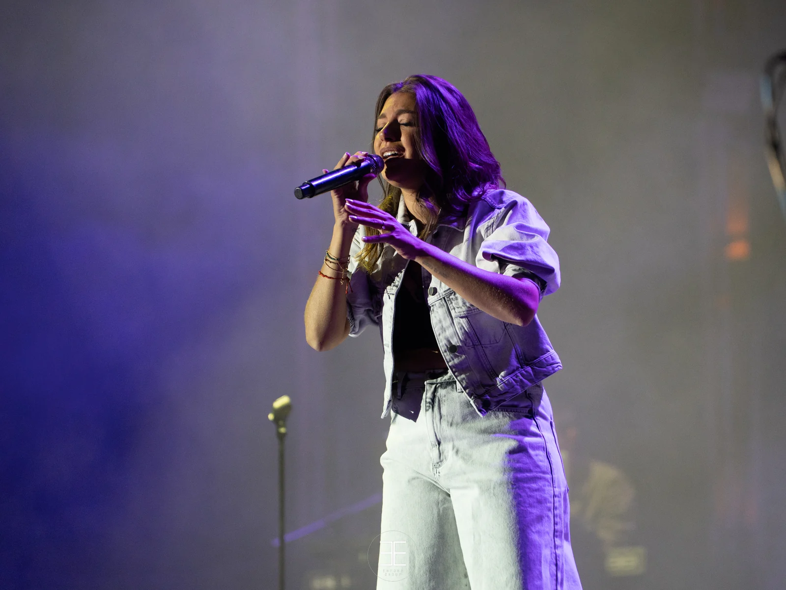 Ana Guerra canta cruzando un brazo ante el pecho bajo una luz morada