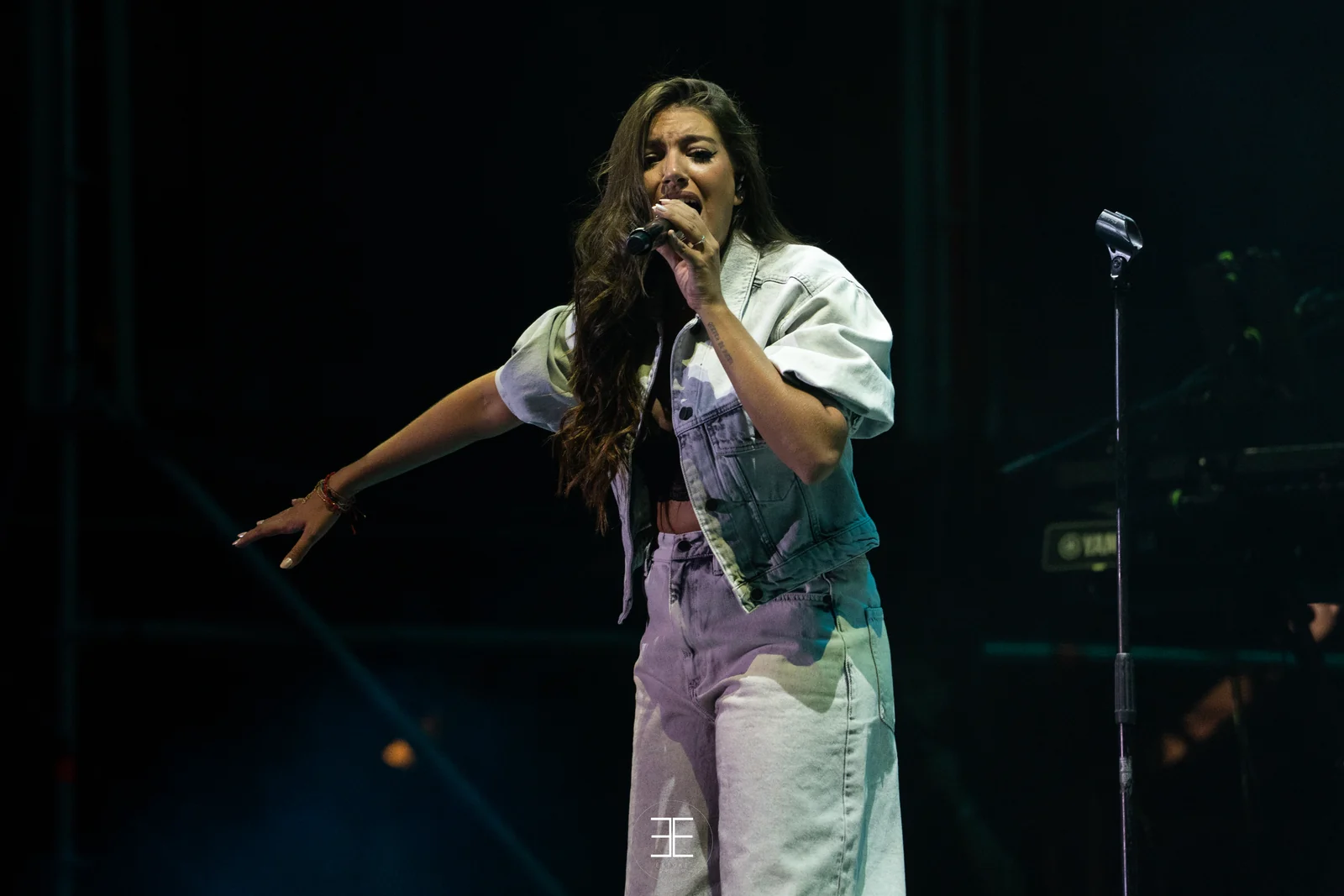 Ana Guerra canta señalando al público con el brazo estirado hacia abajo