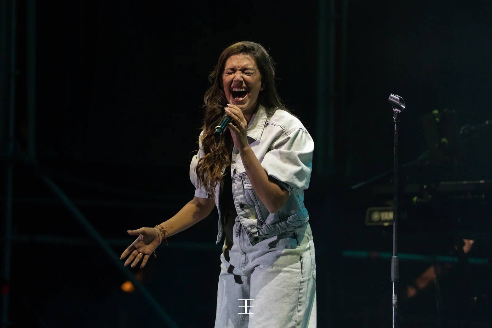 Ana Guerra canta con la boca muy abierta y los dos brazos extendidos a los lados