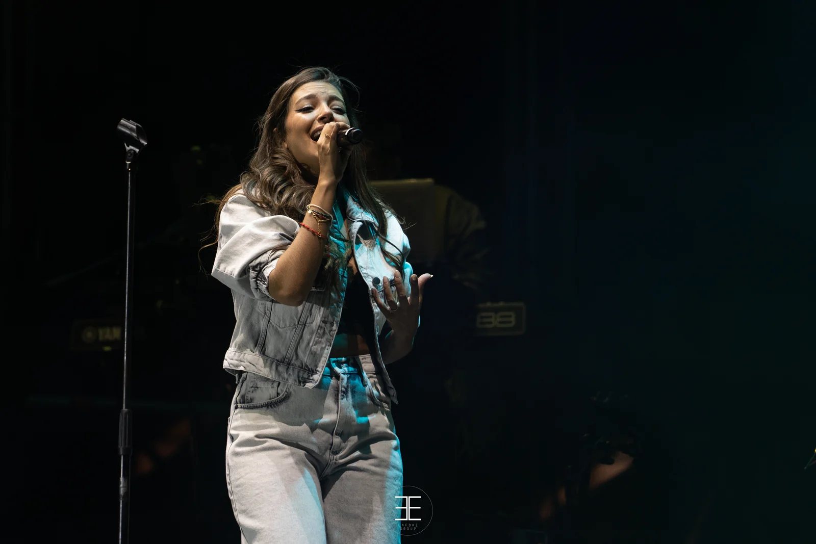 Ana Guerra canta con la mano en el pecho bajo una luz verde