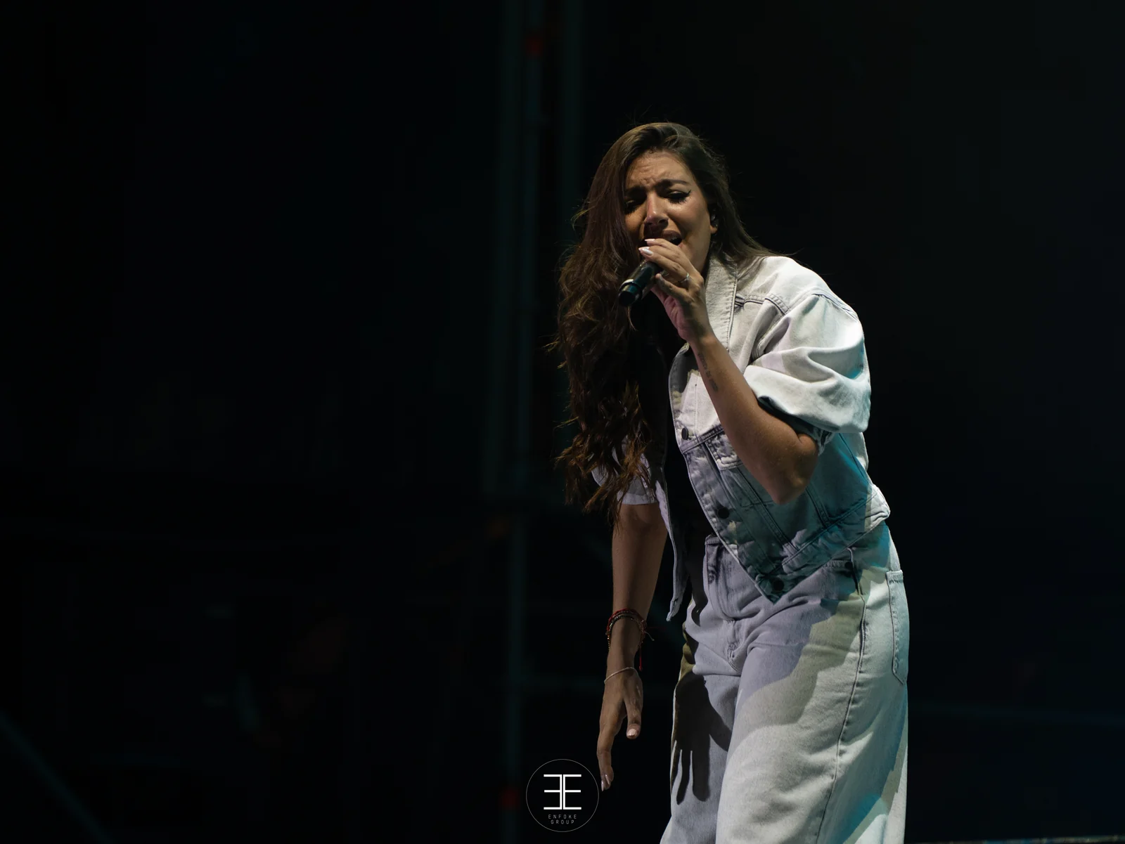 Ana Guerra canta en penumbra, apenas separada del fondo negro