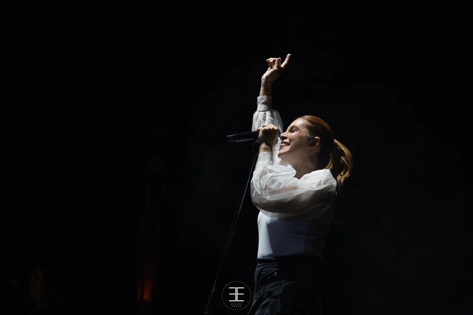 Leire Martínez levanta las dos manos señalando arriba mientras canta