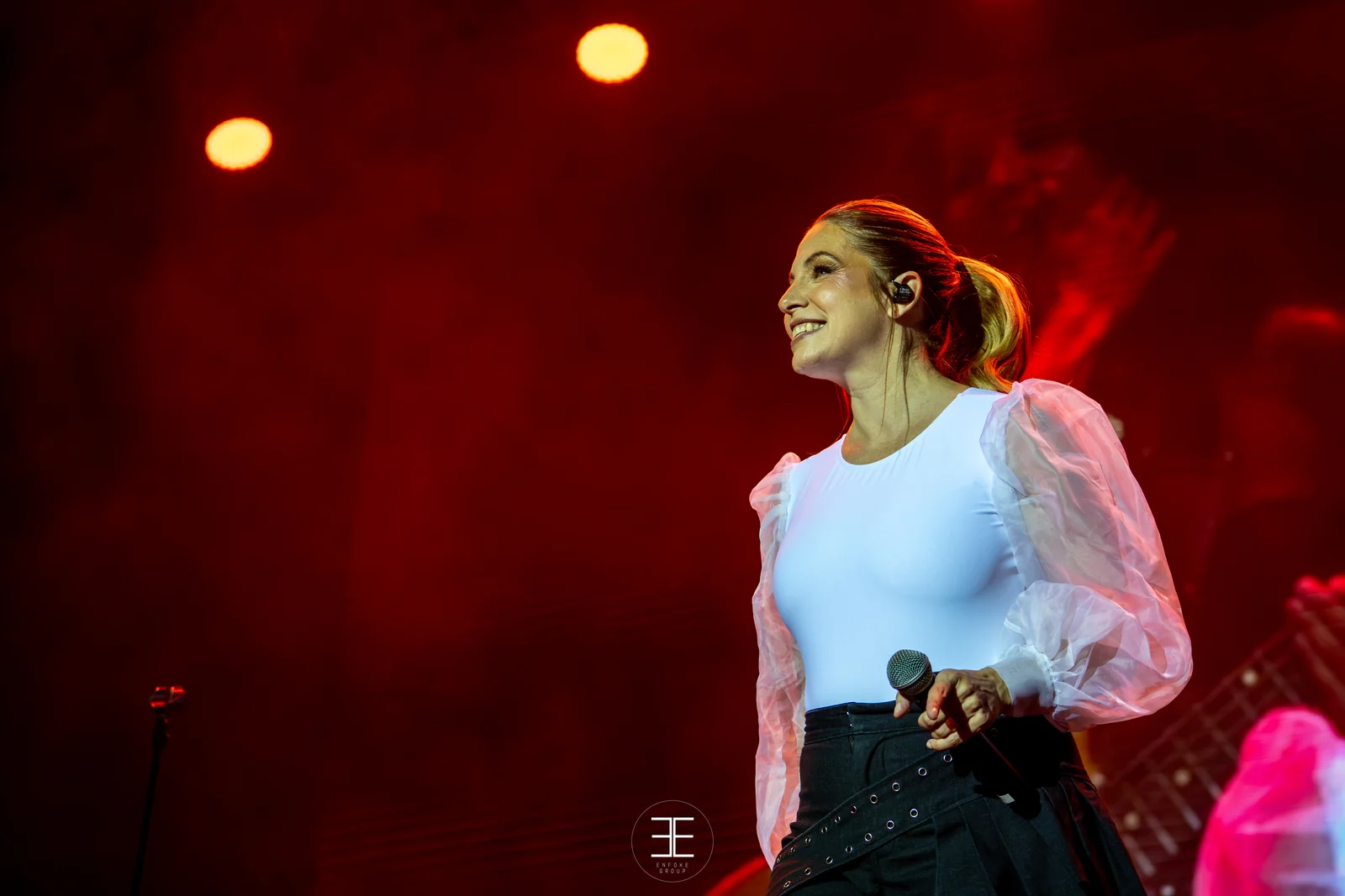 Leire Martínez sonríe mientras canta, recortada sobre un fondo rojo