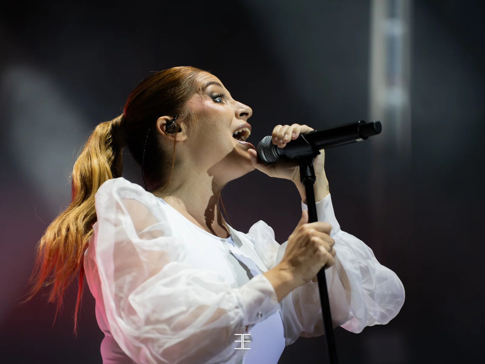 Leire Martínez canta de perfil con el pelo suelto y el micrófono muy cerca de la boca