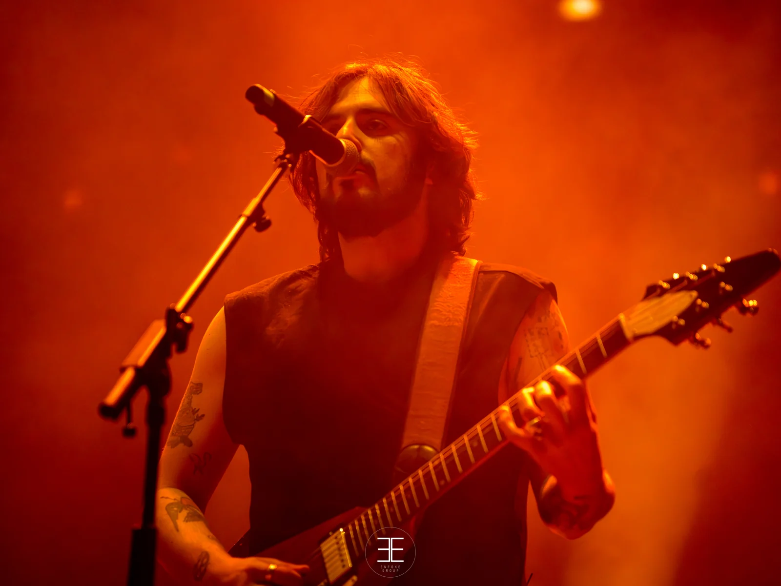 El guitarrista de la banda toca bajo una luz naranja intensa