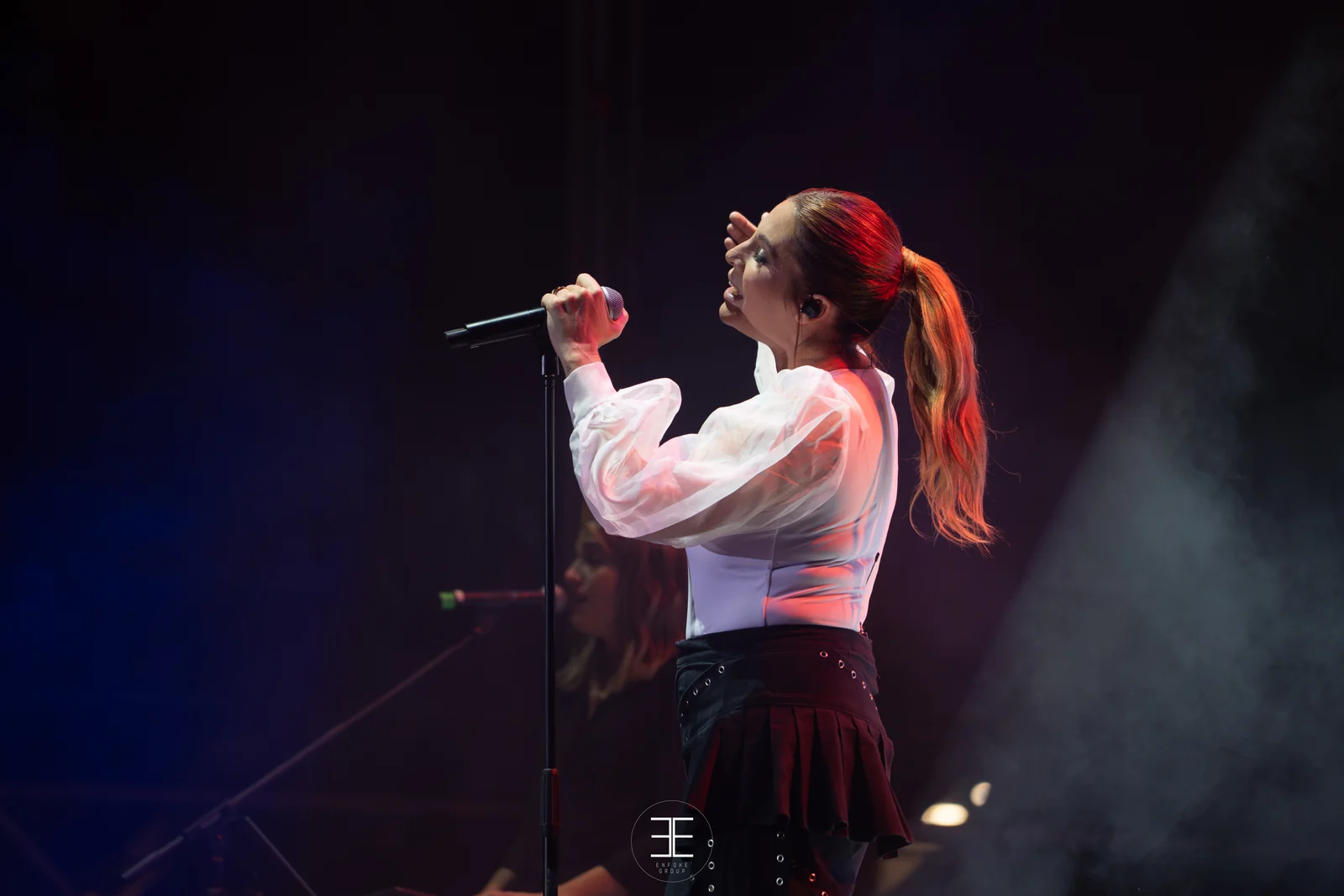 Leire Martínez canta con el micrófono en la mano, rodeada de humo iluminado