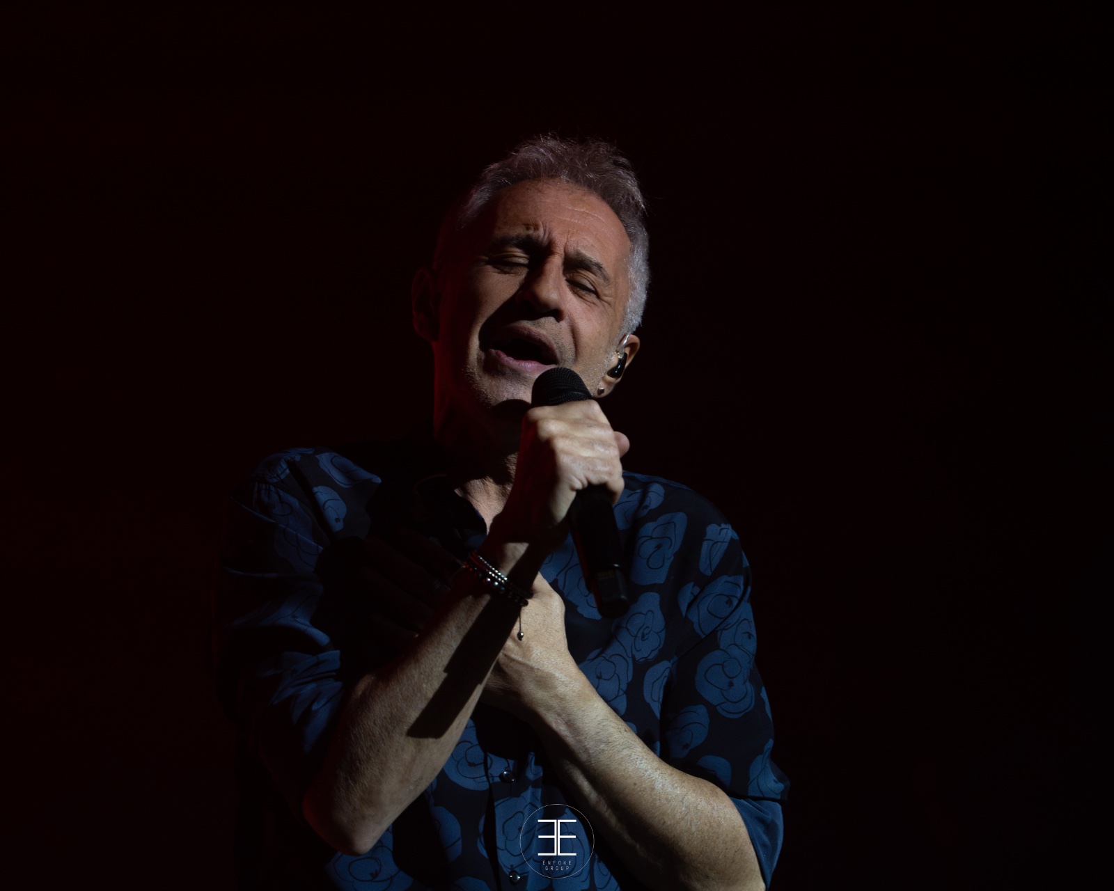 Sergio Dalma canta con los ojos cerrados y la mano en el pecho, casi a oscuras