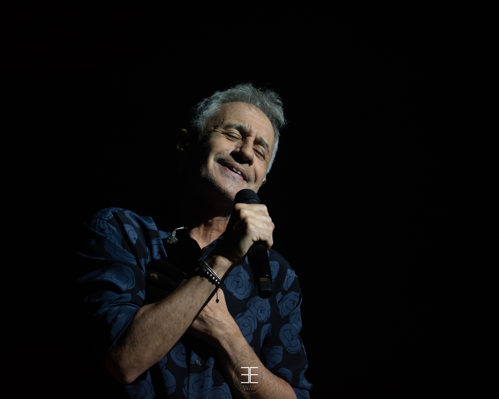 Sergio Dalma sonríe con los ojos cerrados y la mano en el pecho, en la penumbra