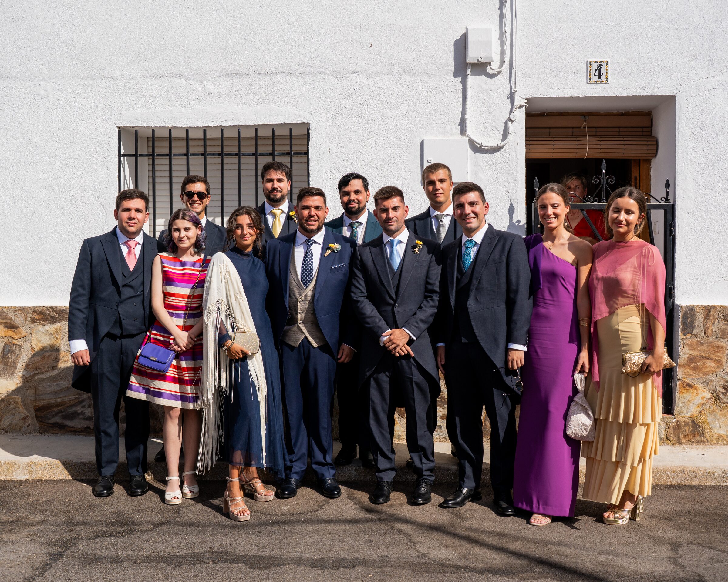 Grupo de amigos posando frente a casa blanca
